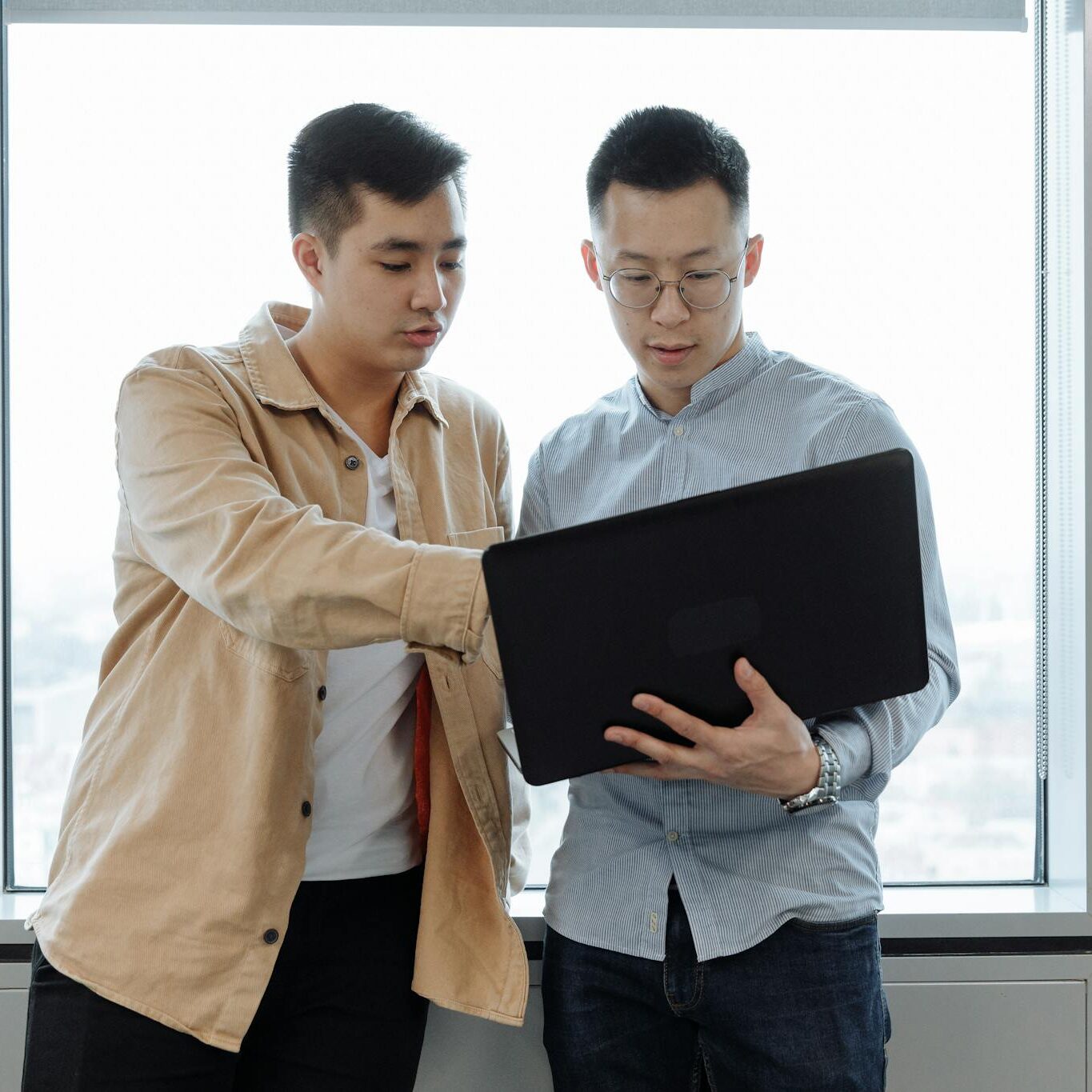 Man in Brown Dress Shirt Holding Black Tablet Computer