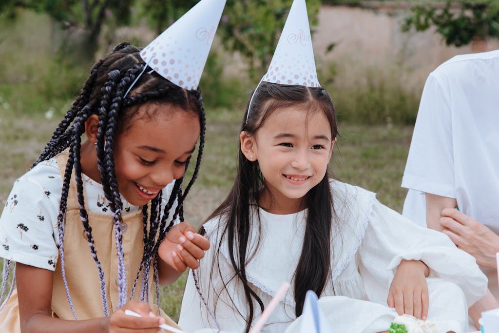 Smiling Girls in Party Hats in Garden